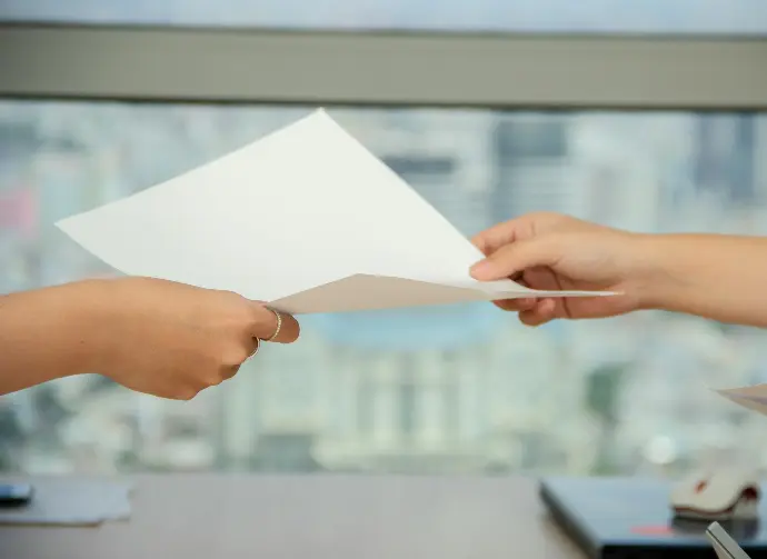 person handing over paper